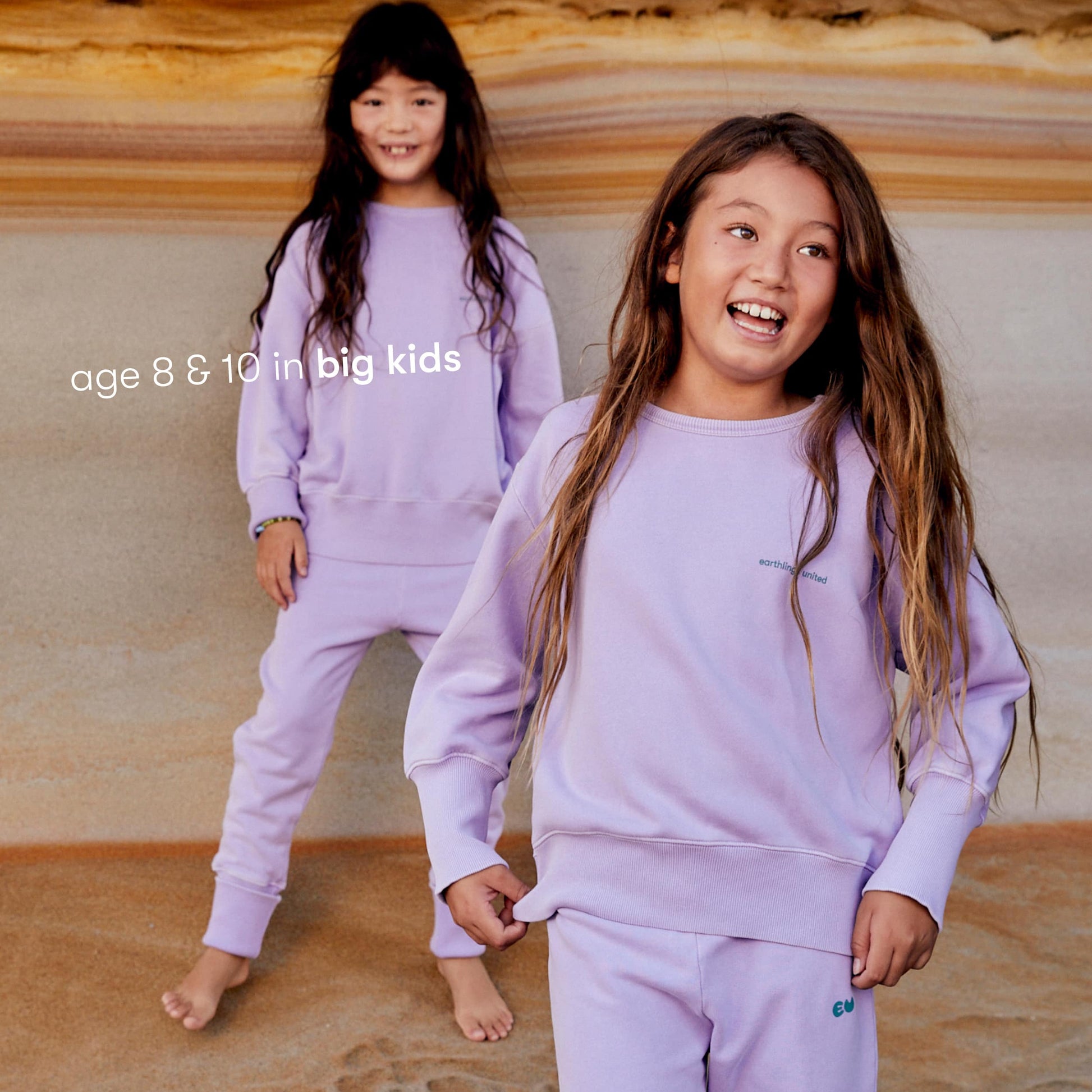 Young girls wearing a sustainable purple kids' jumper by Earthlings United, made from soft organic cotton for comfort and durability