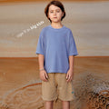 Young boy wearing a sustainable brown kids' shorts by Earthlings United, made from soft organic cotton for comfort and durability