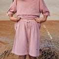 Young boy wearing a sustainable red kids' shorts by Earthlings United, made from soft organic cotton for comfort and durability