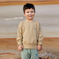 Young boy wearing a sustainable brown kids' jumper by Earthlings United, made from soft organic cotton for comfort and durability