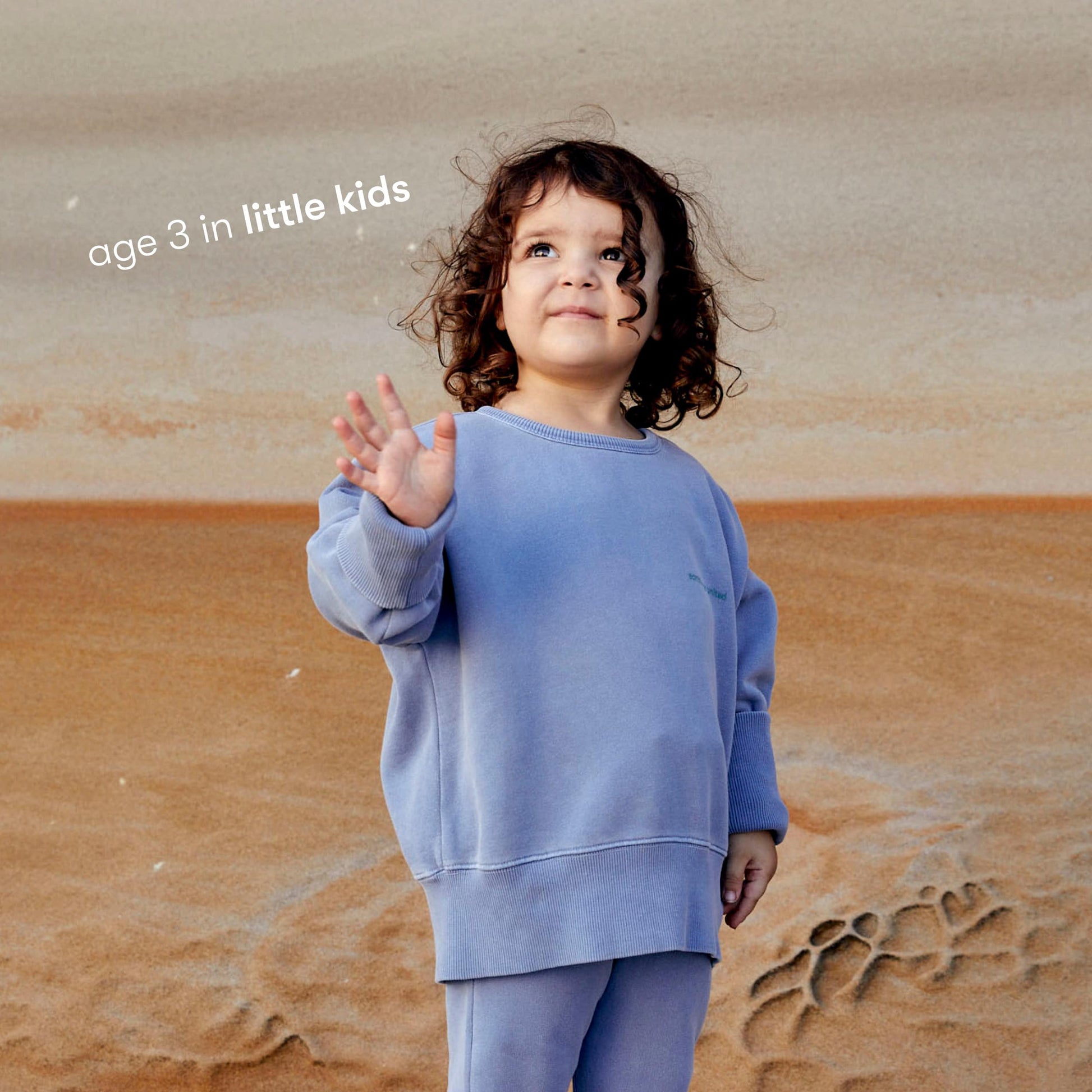 Young girl wearing a sustainable blue kids' jumper by Earthlings United, made from soft organic cotton for comfort and durability