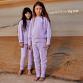 Young girls wearing a sustainable purple kids' jumper by Earthlings United, made from soft organic cotton for comfort and durability